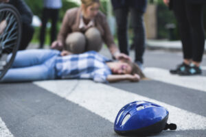 Intersection of an e-bike accident with onlookers standing around the injured young woman